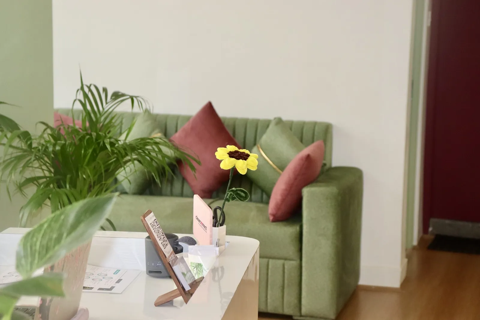 Waiting area with a green sofa and plants